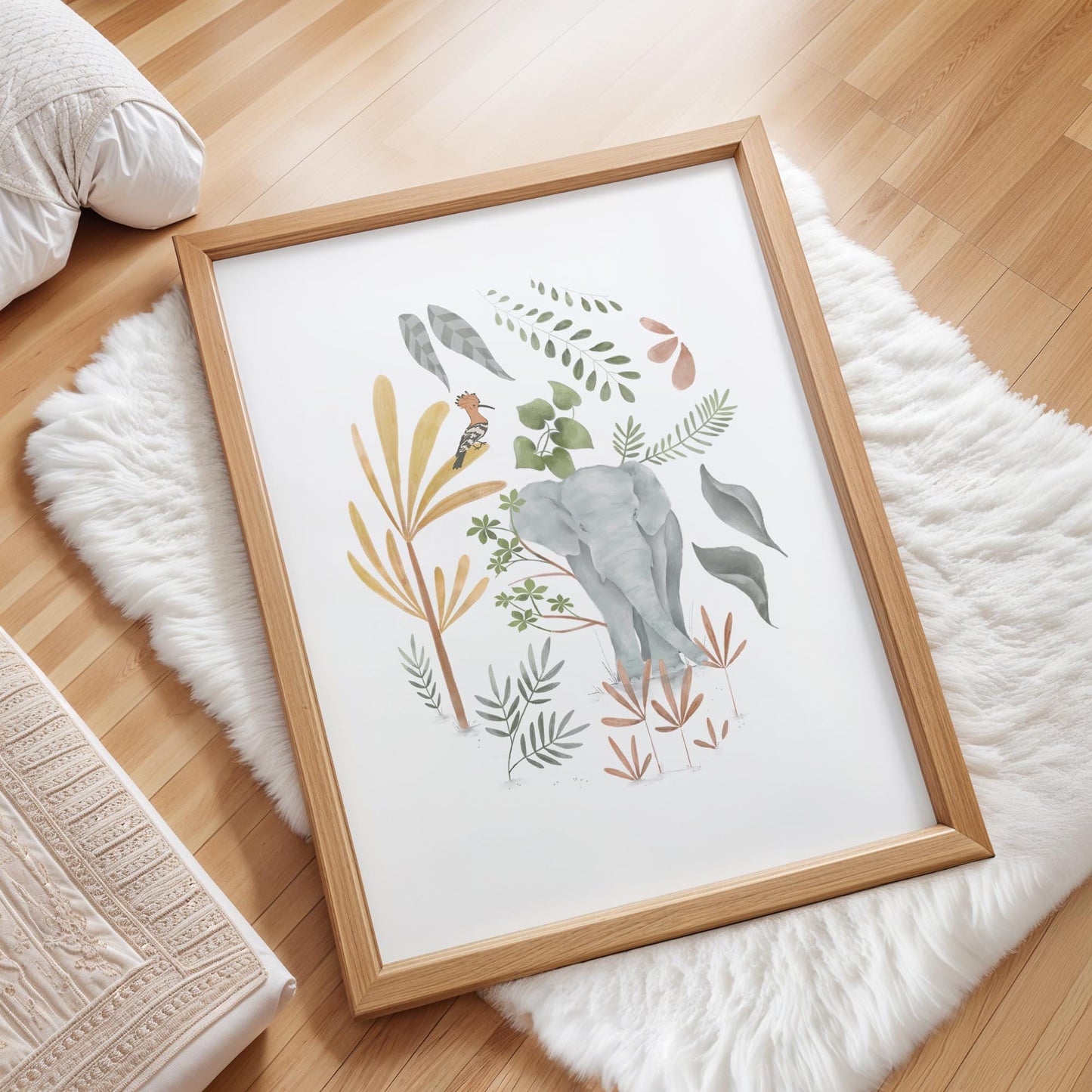 a framed print of a colorful illustration of an elephant surrounded by various plants and flowers, placed on a white fur rug on a wooden floor.