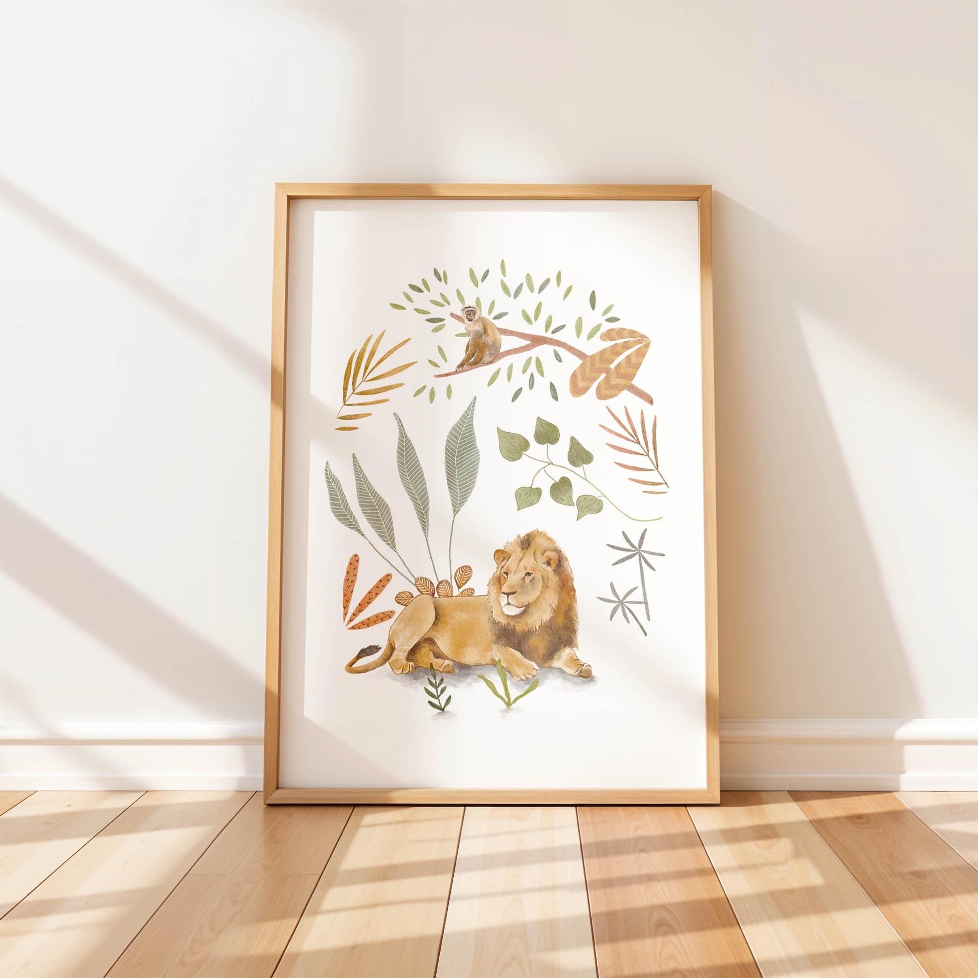 A single framed art print leaning against a white wall. The hand-painted illustration features a majestic lion resting under a tree with a small monkey on a branch above, surrounded by boho botanical leaves.